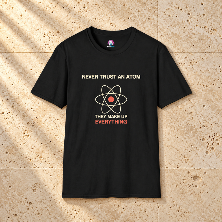 Never Trust an Atom Science T-Shirt — black shirt on beige travertine
